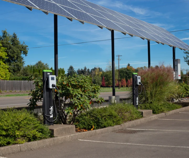 Public charging stations in a sunlit parking lot, energized by solar panels, offering both Level 2 AC Charging and Level 3 DC Fast Charging