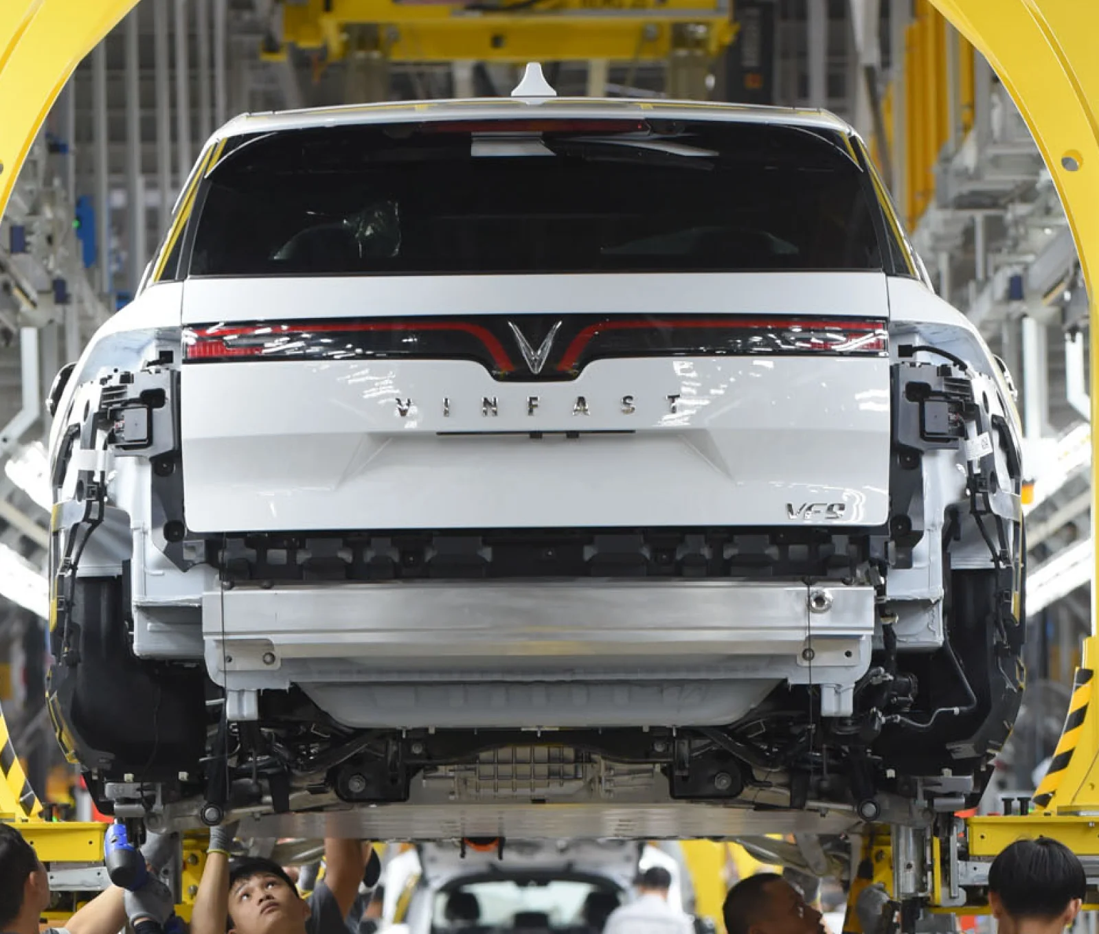 Close-up of a white VinFast VF 9 being built, ensuring long-term reliability with its electric vehicle battery warranty