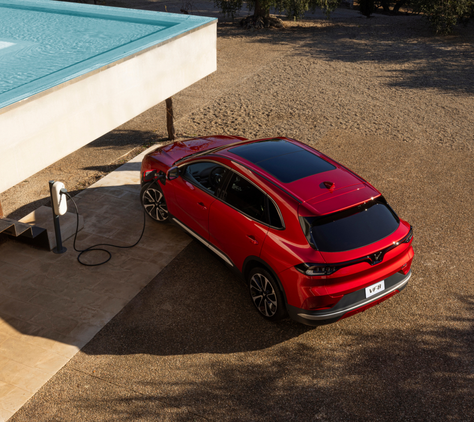 Shiny Crimson Red VinFast VF 8 charging on the sand